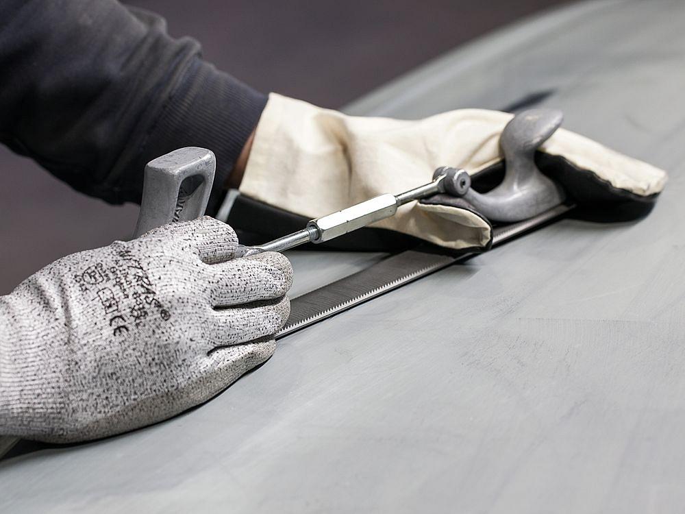 Manuelle Bearbeitung eines Metallprototyps – Feinanpassung und Oberflächenbearbeitung Detailaufnahme der handwerklichen Bearbeitung eines Prototypen mit Feile und Werkzeugen