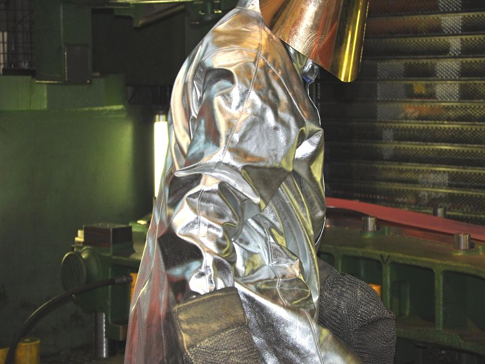 Worker wearing heat-protective clothing during the hot forming of a prototype component