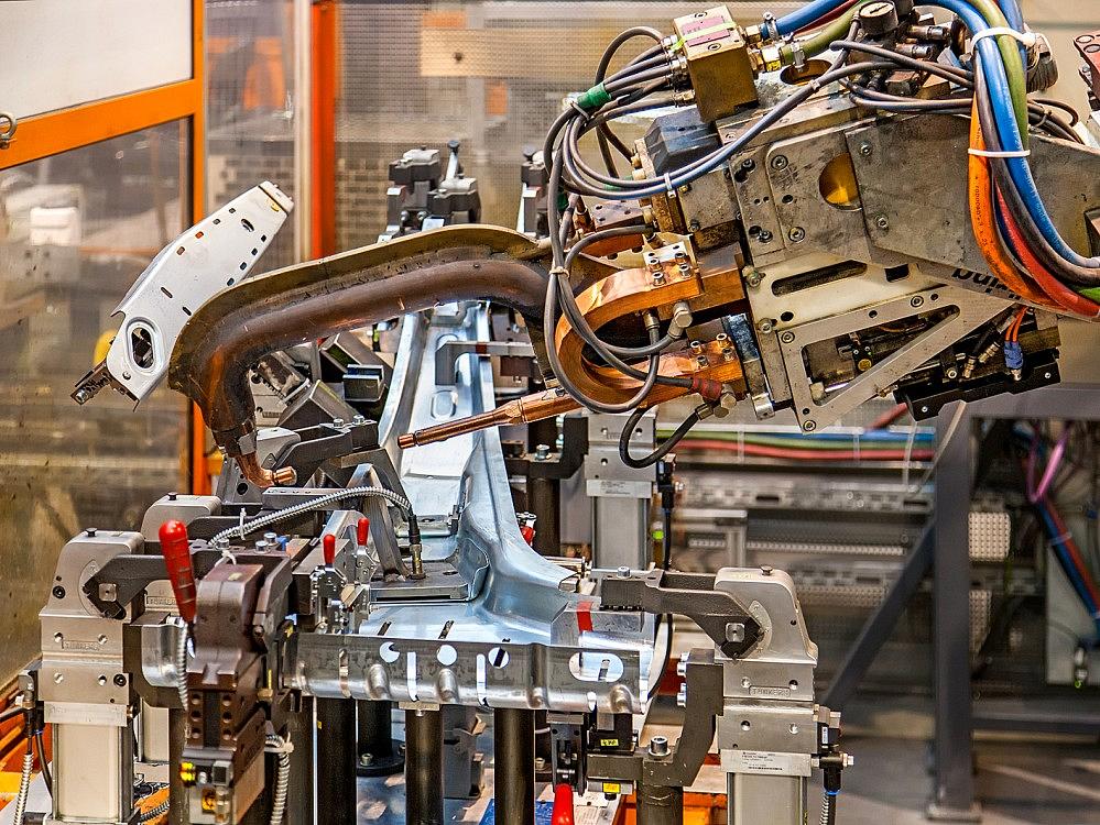 Automated assembly manufacturing – welding robot in operation Welding robot processing metal components in automated assembly production